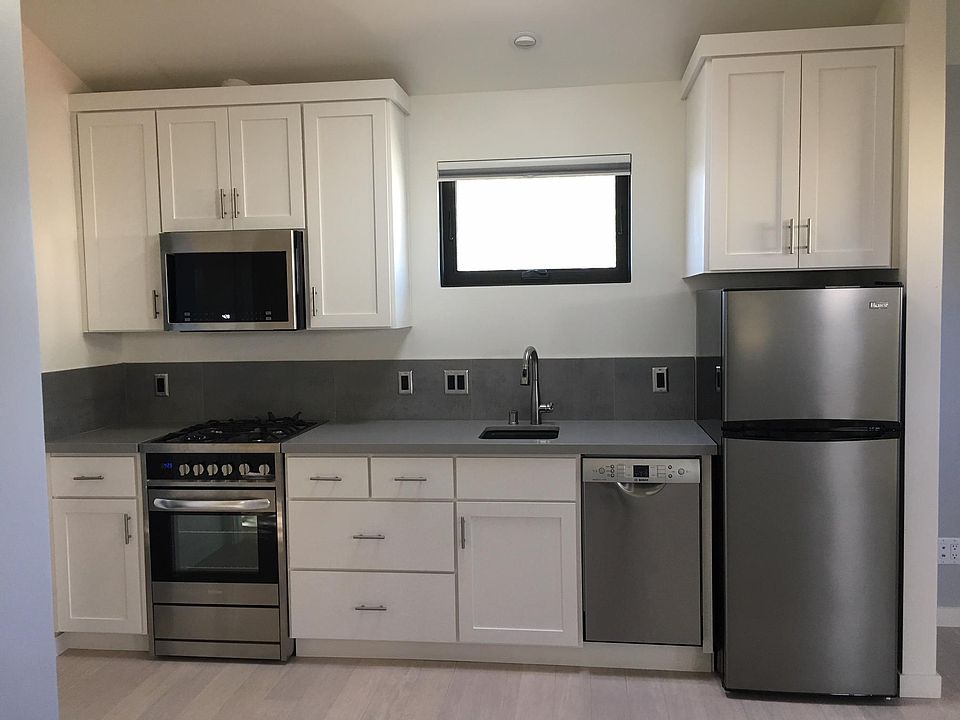 Modern kitchen with gas stove, Bosch dishwasher, stainless steel appliances. Bamboo flooring throughout.