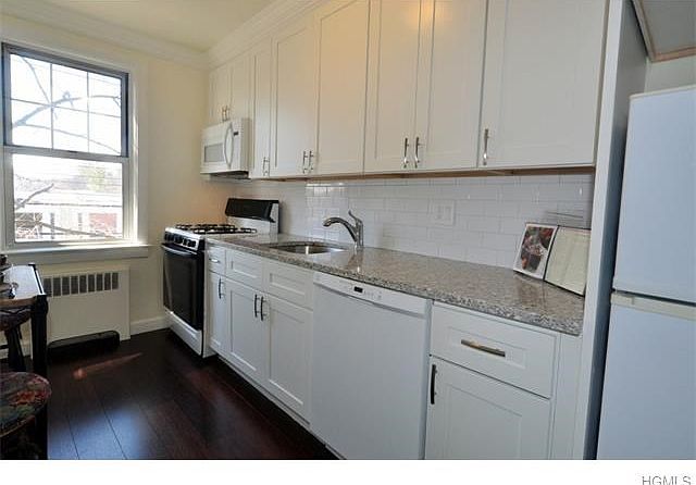 New Kitchen with granite counters, custom cabinets, crown molding and new appliances included dishwasher, microwave, range and refrigerator.