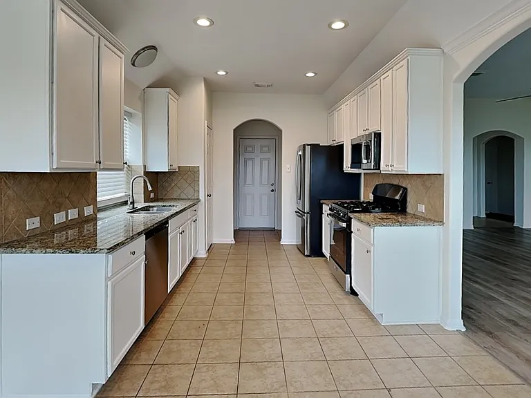 Spacious kitchen with white ca