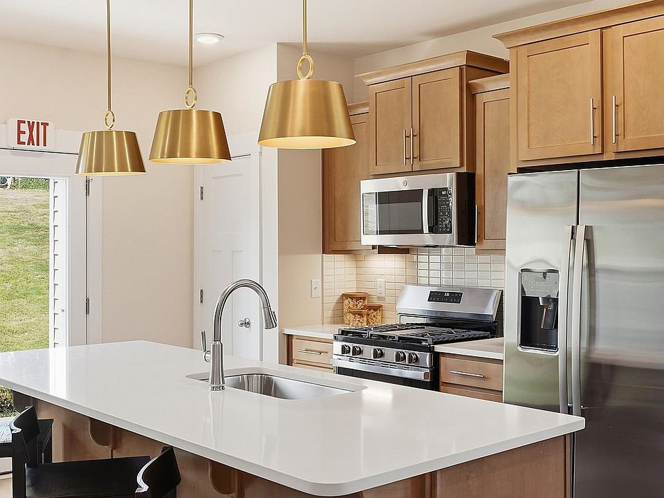 Highly skilled design choices create a clean, open kitchen with a central island in this townhome at