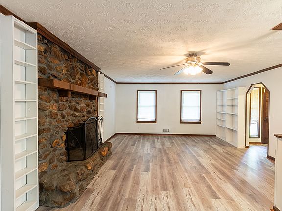 Living room with a stone fireplace, built-in bookcases and new LVP flooring