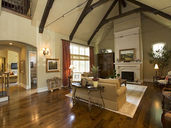 Gorgeous vaulted and beamed great room with fireplace and hardwood floors.