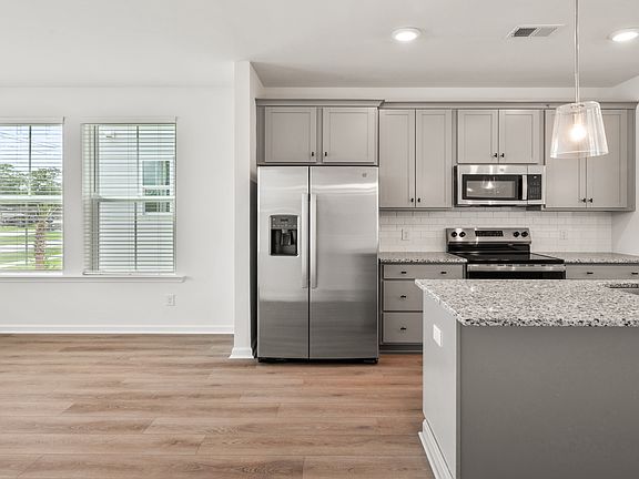 Kitchen in Hayden Floorplan with large island and lots of natural light at Clear Springs Townhomes
