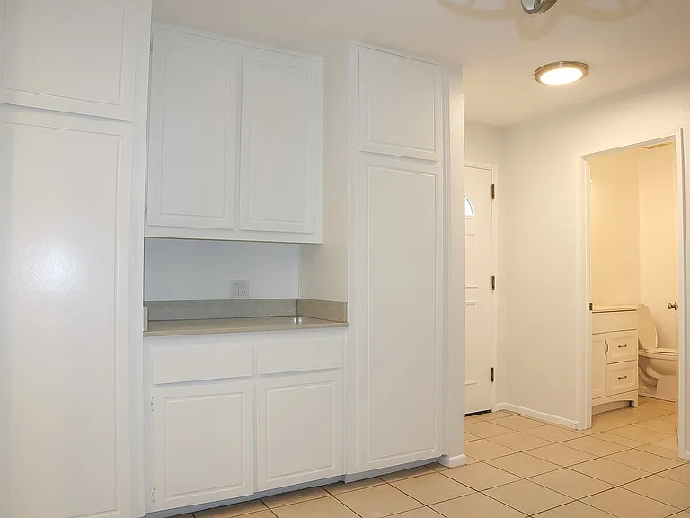 Dining Room cabinets with the main entrance door on the right, followed by the downstairs guest bathroom.