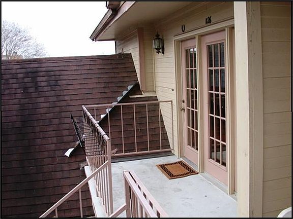 BALCONY OUTSIDE THE FRENCH DOORS OVERLOOKING THE PARK LIKE SETTING.