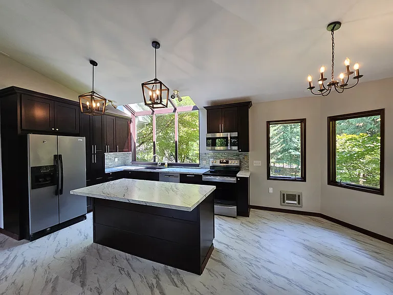 Stunning kitchen with modern fixtures, stainless steel appliances and formal dining area.