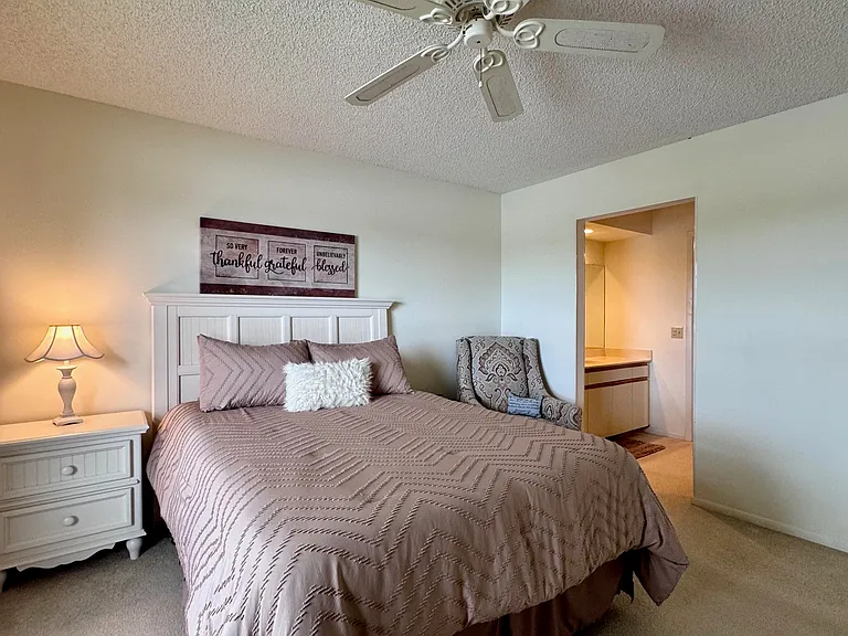 Spacious Primary Bedroom w/ stunning expansive lake & golf course views + a HUGE walk-in closet & walk-in shower!
