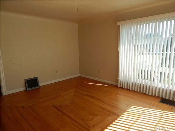 Enter to light and bright living room with wood floors and coved ceilings.