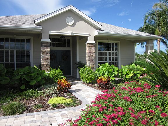 Lovely tropical landscaping surrounds the home.