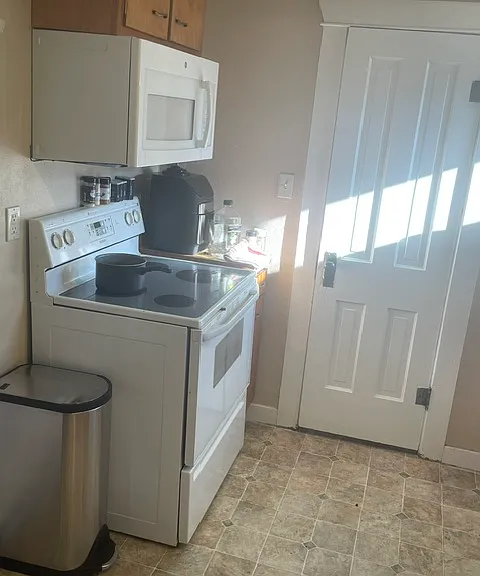 Electric stove, microwave and air fryer. Door leads to large pantry. Lots of storage!