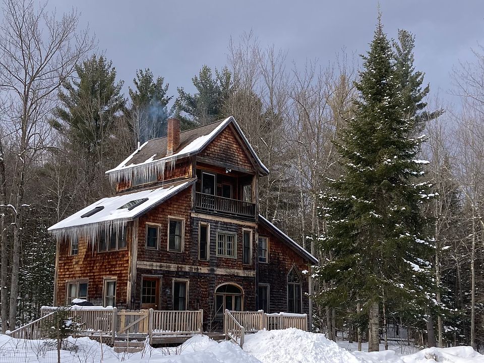 Cedar shingled home with a large front deck, a small back porch, and a balcony on the third floor. Views of Laraway and Butternut.