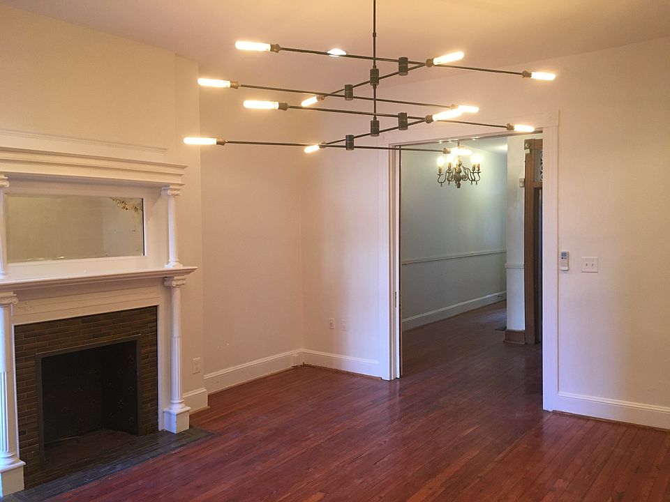 Living room with large statement light and fireplace.