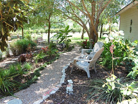 One of the many paths through lush gardens/view of detached 2-car garage