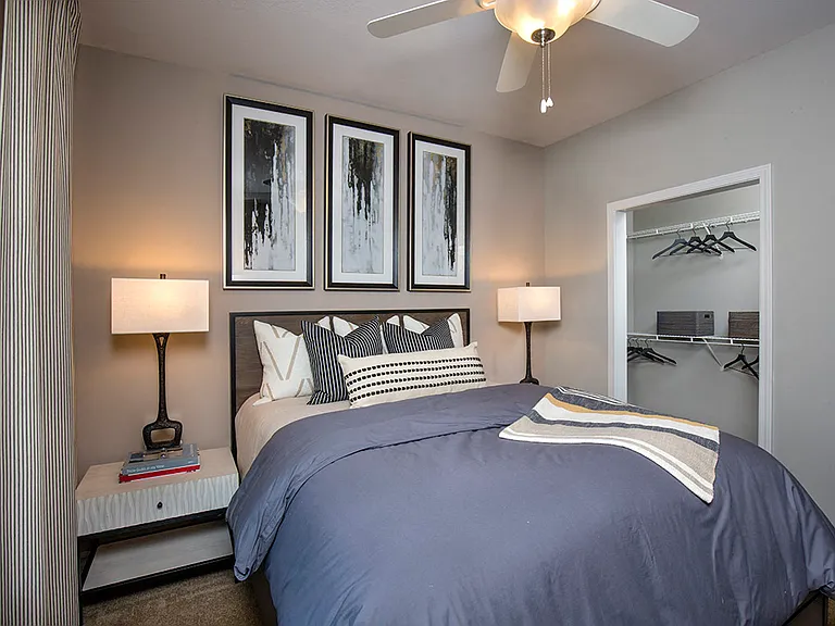Secondary bedroom with ceiling fan and walk-in closet