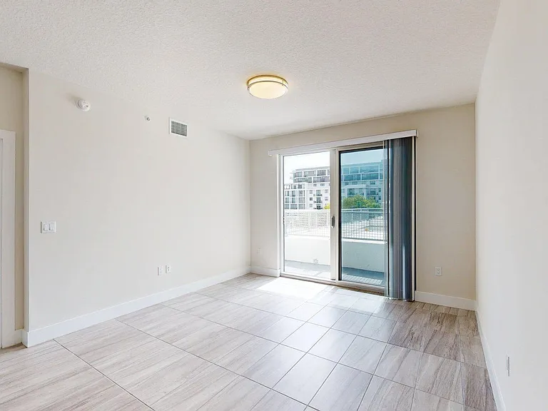 Apartment living room with wood style floors and balcony.