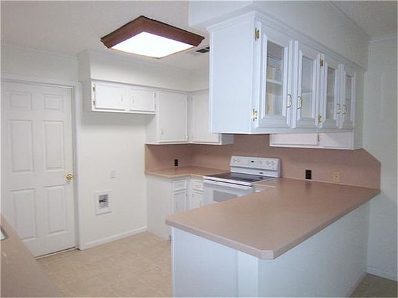 Light and bright kitchen with painted cabinetry, glass front cabinets - refrigerator can be included