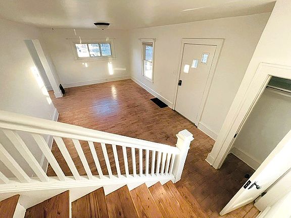 View of living room from stairway to second level. Convenient small coat closet near front door.