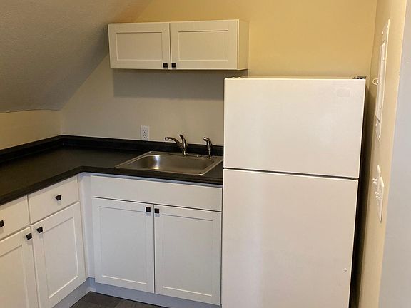 New kitchen with floor, cabinets, sink and countertop.