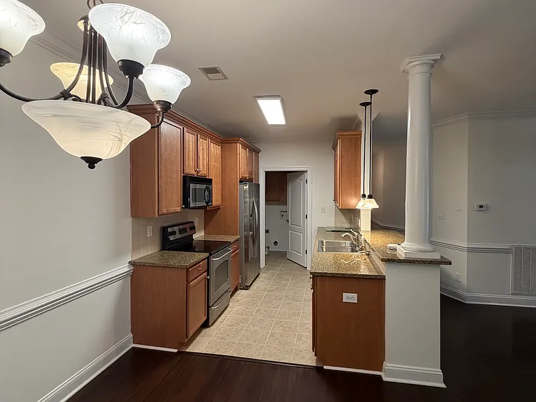 looking into kitchen from dining area and can see the bar height granite for 2 stools for extra seating/entertaining right of picture