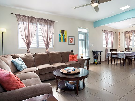 Living and dining area with sectional sofa, large TV, DVD, books, games, and streaming services. Ceiling fans throughout home and patio.