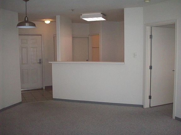 View of entry, kitchen, bedroom door, from living room.