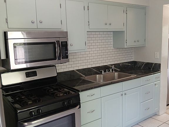 Stainless steel appliances, subway tile backsplash and granite countertop