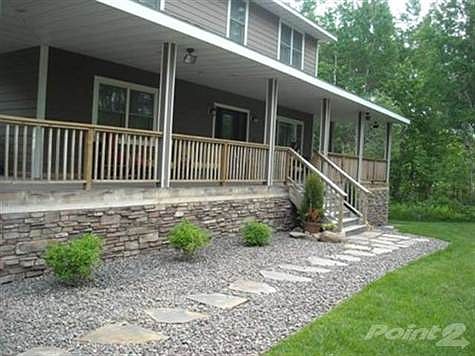 Summer view of front entrance with landscaping