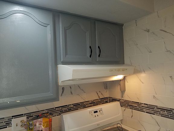 Kitchen Marbled Backsplash & Gas stove range, kitchen cabinets