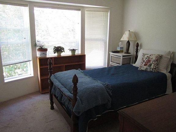 This bedroom is at the opposite end of the home from the kitchen. It too has large windows and the view is into trees. These trees block the neighbors from view. The room is very comfortable with big closet space. Love the storage in this home!