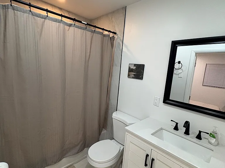 Well-appointed bathroom featuring a tub/shower combo, spacious vanity with storage, and updated fixtures.