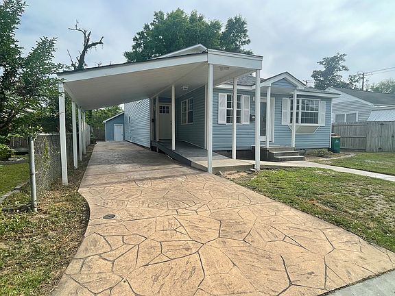 Front view with carport and detached garage