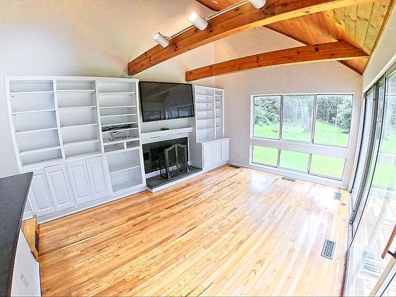 Family room with vaulted ceilings, fireplace and large windows overlooking the backyard