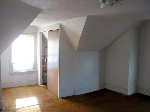A spacious bedroom with laminate flooring, and plenty of light.