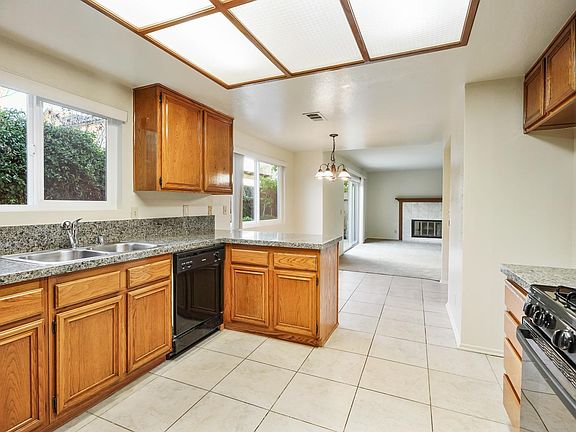 CENTRALLY LOCATED MODERN KITCHEN WITH GRANITE COUNTERS, NOOK WET BAR HAS A VIEW OF FAMILY ROOM FIREPLACE.