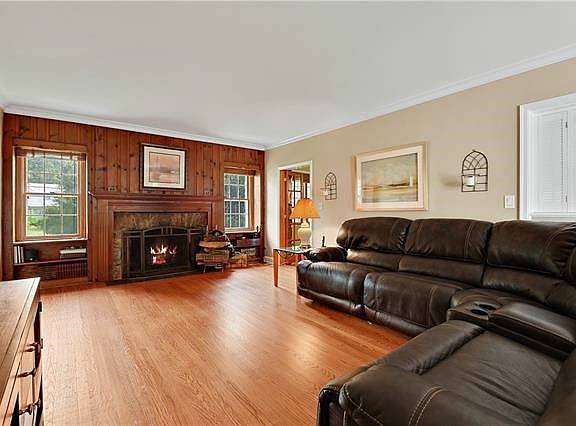 Living room with majestic stone fireplace & adjacent den/office.