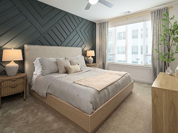 Experience serenity in this elegantly designed bedroom featuring cozy textures and calming colors.