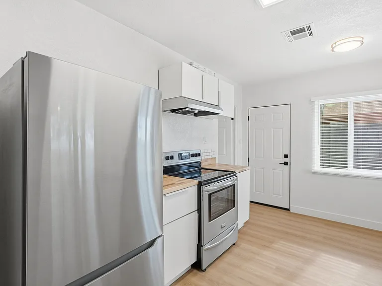 Stainless steal alliances. Large fridge w/ freezer drawer on the bottom. Side entrance to back lot.