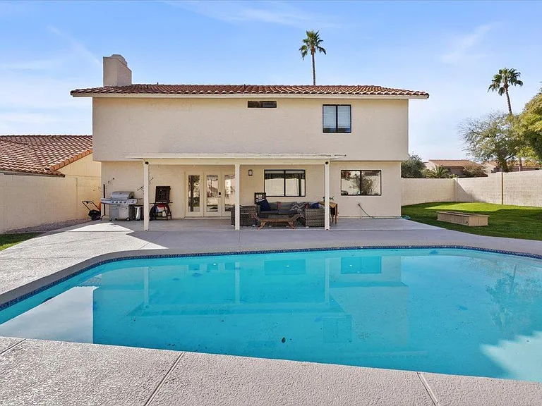 Private backyard with covered patio and large pool.
