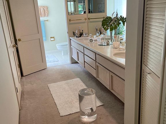 Primary Bedroom double sinks and bathroom with skylight. Walk-in closet is on left.
