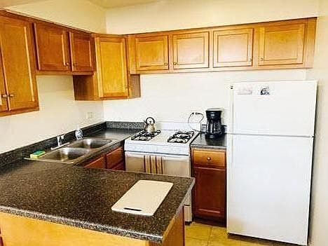 great kitchen with lots of cabinets, double sink and breakfast bar that opens to room
