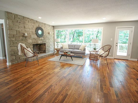 Spacious great room with wood floors and woodburning fireplace