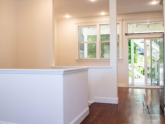 Upper level viewed from just inside front door, looking towards the rear of the unit. This level includes dining area, kitchen, living room, main bedroom and bath. Upstairs level has high ceilings, recessed lighting on dimmers and refinished, original woo
