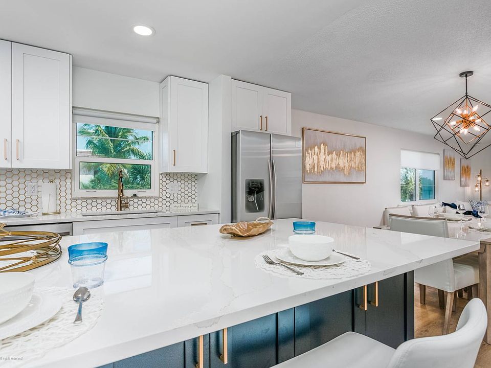 Kitchen has Carrera Marble Backsplash and Stainless Steel Appliances