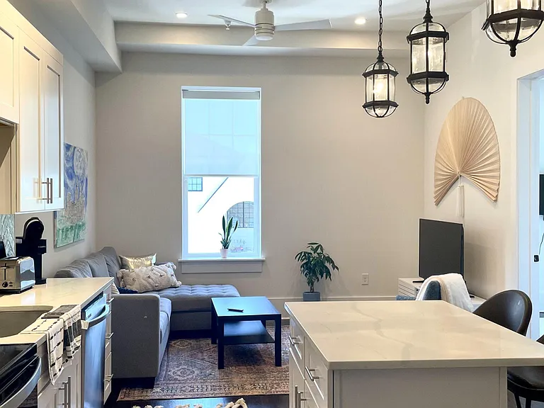 Your spacious kitchen with a luminescent pearl backsplash, level eight quartz countertops and high end cabinetry transitions seamlessly to a living room area built for hosting or just relaxing with your favorite movie.