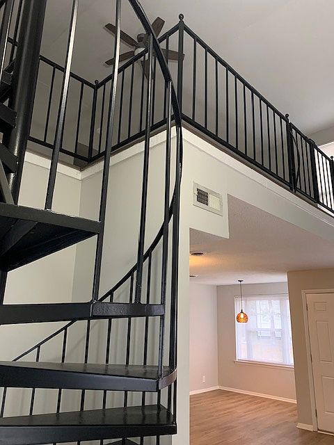 Looking up to loft bedroom from entryway. Dining area in background.