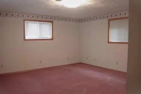 This room is bigger than it looks. Pink carpet is being replaced with warm beige.