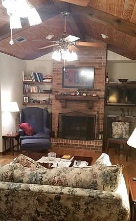 Living room featuring a wood burning fireplace, wood floors, architectural, and wired for surround sound