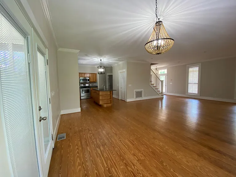 Open concept kitchen, dining, living area. French doors open to a screened breezeway/screened porch.