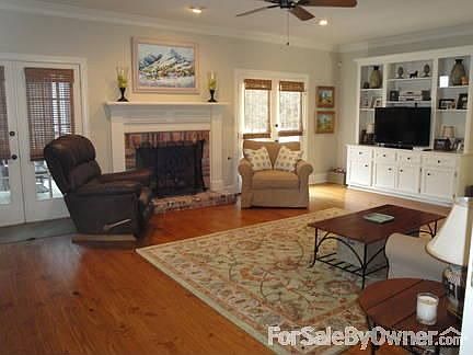 Living Room : Open living area with built-in bookcase/TV area, fireplace, hardwood floors.