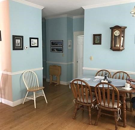 The kitchen is to the left of this dining/living area.